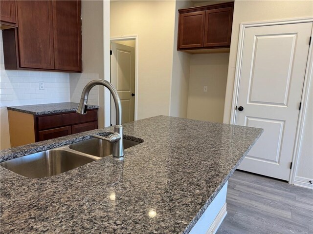 kitchen with ceiling fan, a kitchen island with sink, dark hardwood / wood-style floors, and sink