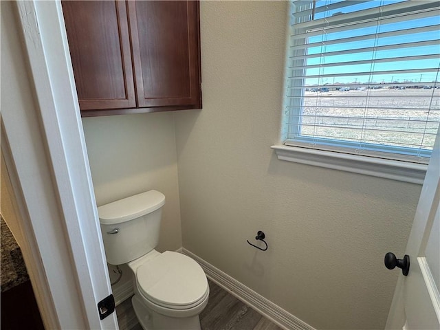 bathroom featuring toilet, baseboards, and wood finished floors