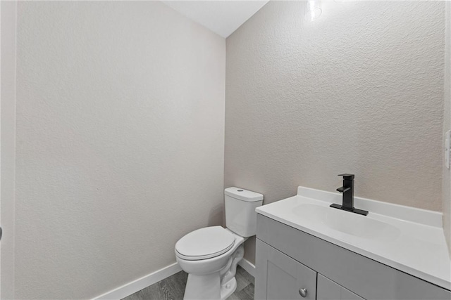 bathroom with vanity, wood-type flooring, and toilet