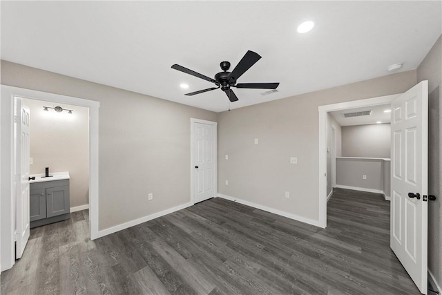 unfurnished bedroom with ensuite bathroom, dark hardwood / wood-style flooring, and ceiling fan