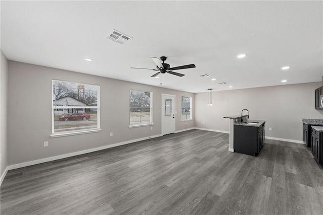 unfurnished living room with ceiling fan, sink, and dark hardwood / wood-style floors