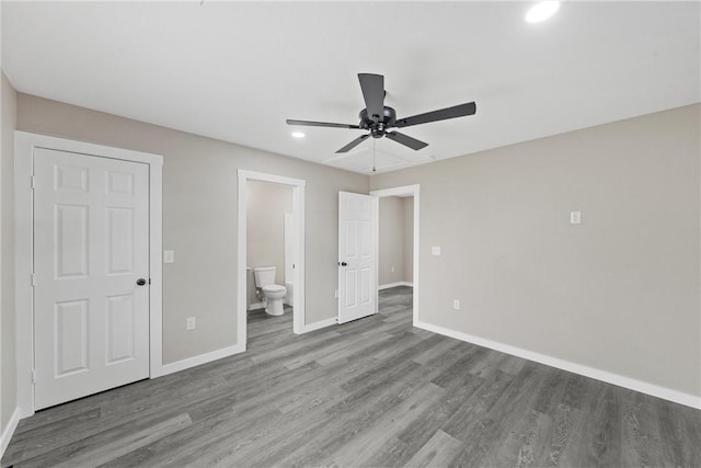 unfurnished bedroom with ensuite bathroom, hardwood / wood-style floors, and ceiling fan