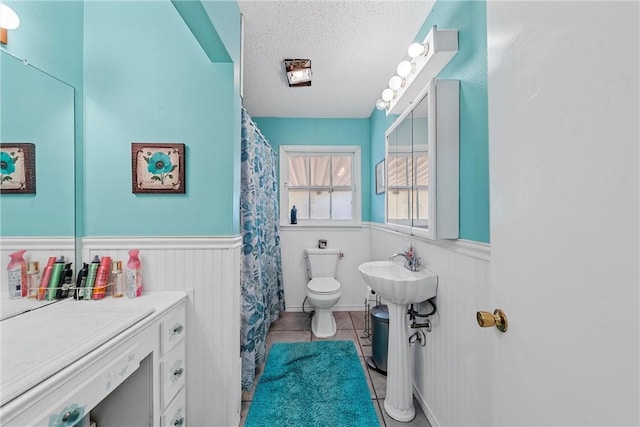 bathroom with tile patterned floors, a textured ceiling, and toilet