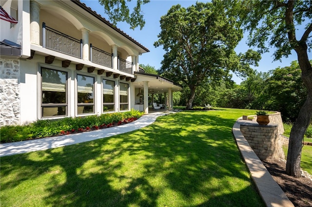 view of yard with a balcony