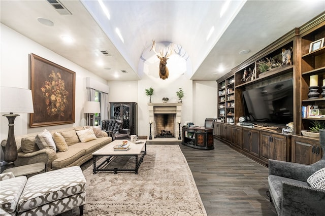 living room with built in shelves, dark wood-type flooring, and vaulted ceiling