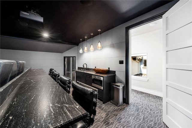 carpeted cinema room featuring lofted ceiling and sink