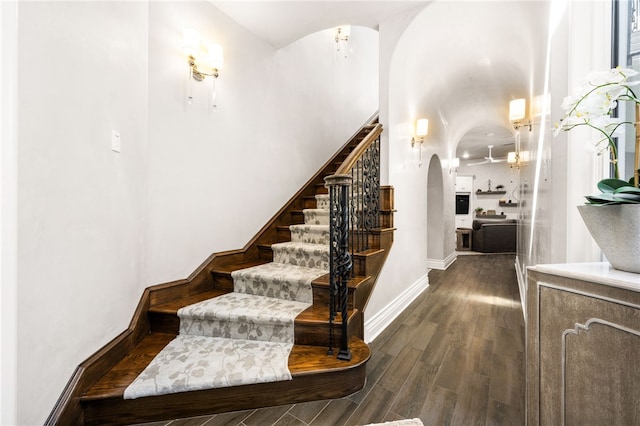 stairs with hardwood / wood-style floors and ceiling fan