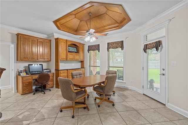 tiled dining area with a tray ceiling, ceiling fan, and ornamental molding