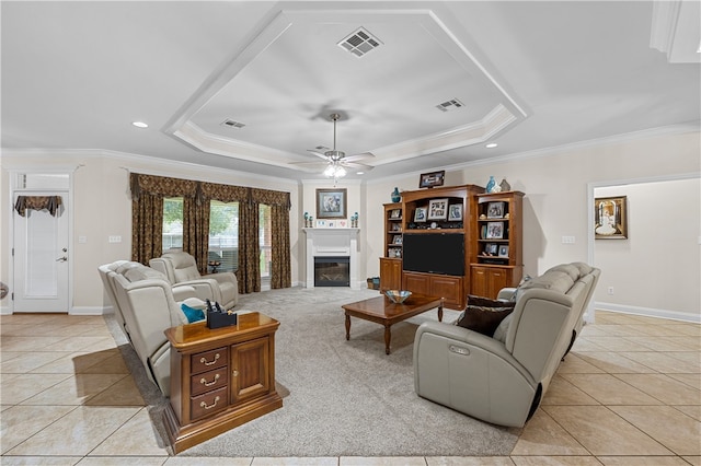 tiled living room featuring a tray ceiling, ceiling fan, and ornamental molding