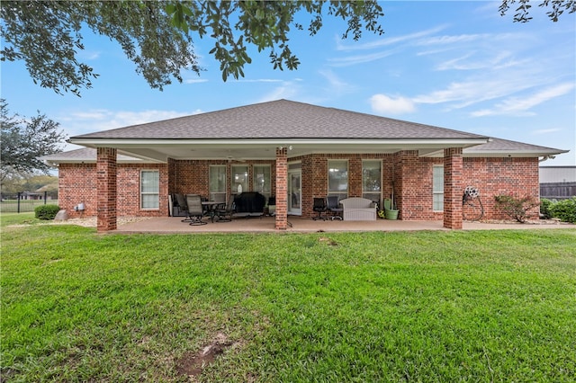 rear view of house featuring a patio and a lawn