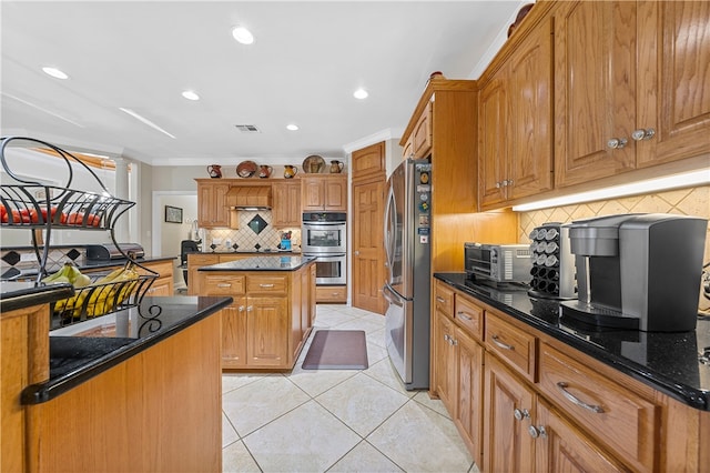 kitchen featuring decorative backsplash, appliances with stainless steel finishes, crown molding, light tile patterned floors, and dark stone countertops