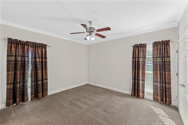 empty room with ornamental molding, carpet floors, and a wealth of natural light