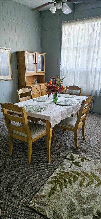 dining space with ceiling fan and carpet floors