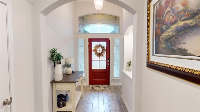 foyer with hardwood / wood-style floors and vaulted ceiling