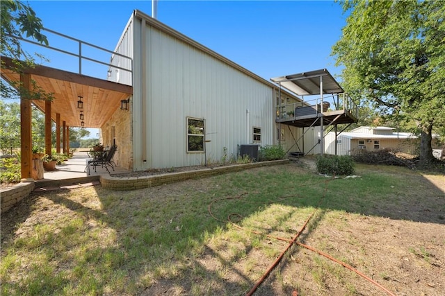 view of side of home featuring central AC unit and a lawn