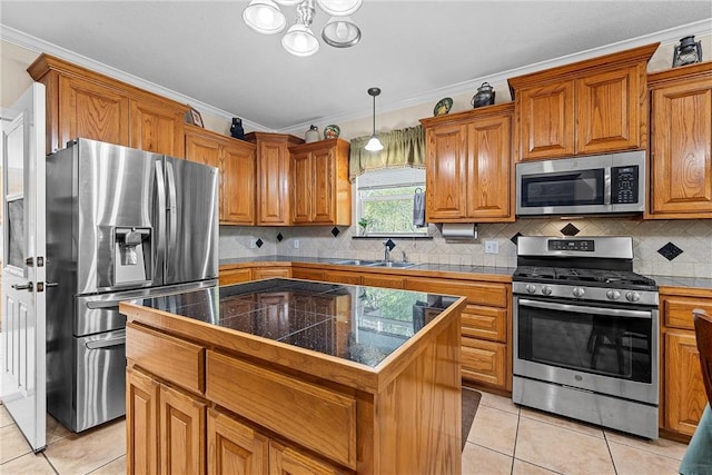 kitchen with appliances with stainless steel finishes, a center island, and ornamental molding