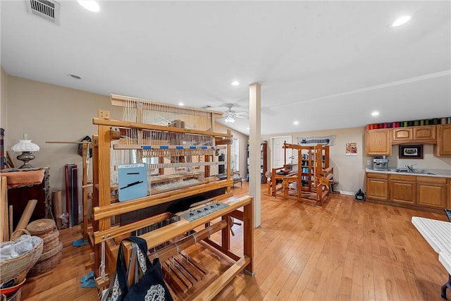 dining area featuring ceiling fan, light wood-type flooring, and sink