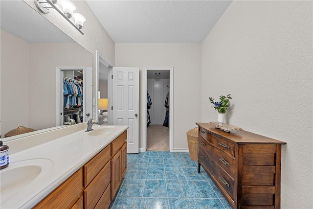 bathroom with vanity, a textured ceiling, and tile patterned flooring