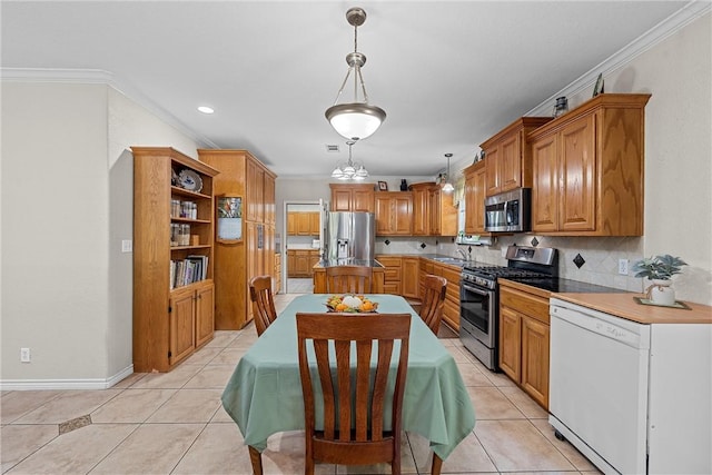 kitchen featuring decorative light fixtures, light tile patterned floors, stainless steel appliances, and tasteful backsplash