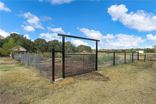 view of gate with a rural view