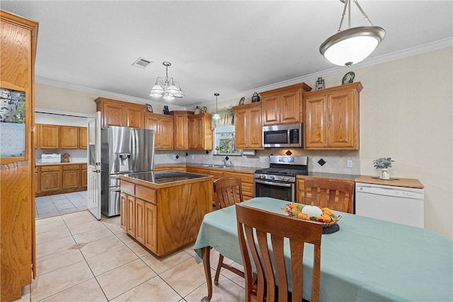 kitchen featuring pendant lighting, sink, crown molding, stainless steel appliances, and a chandelier