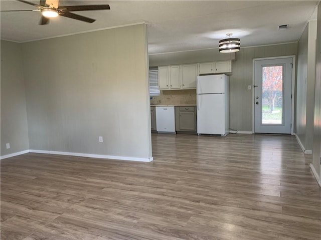 kitchen with ceiling fan, backsplash, white appliances, wood-type flooring, and ornamental molding