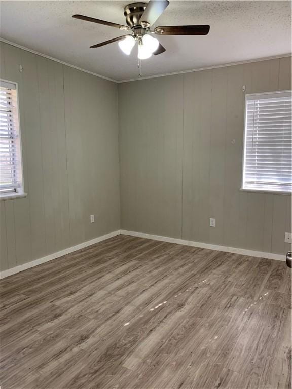 empty room with ceiling fan, a textured ceiling, and hardwood / wood-style floors