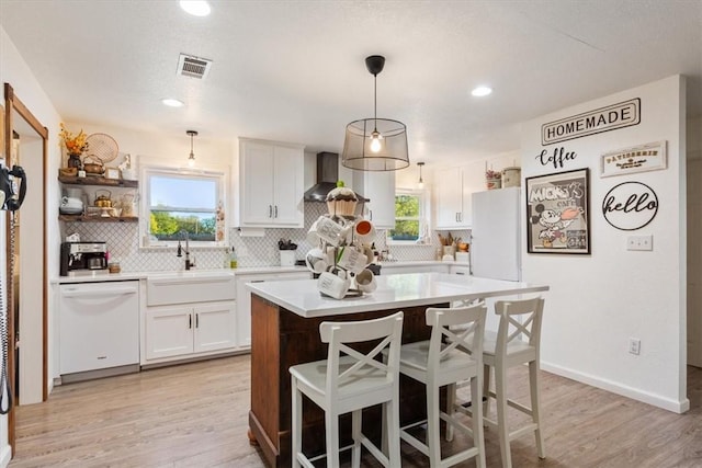 kitchen with white cabinetry, plenty of natural light, and white appliances