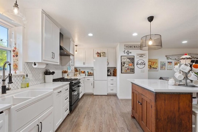 kitchen featuring wall chimney exhaust hood, white cabinets, and white appliances