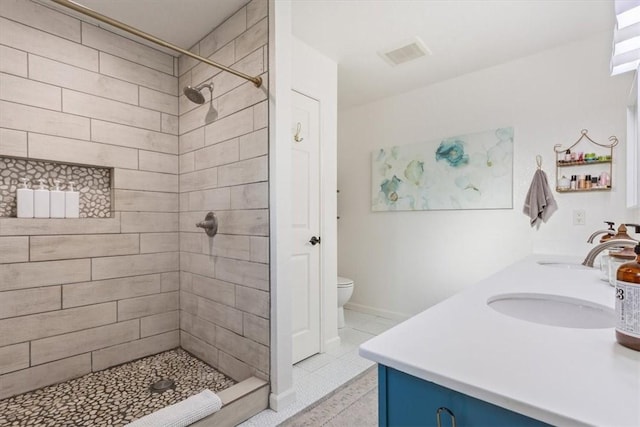 bathroom featuring tiled shower, tile patterned flooring, vanity, and toilet