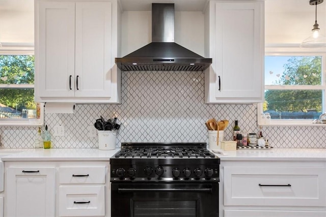 kitchen featuring white cabinets, decorative backsplash, high end range, and wall chimney range hood