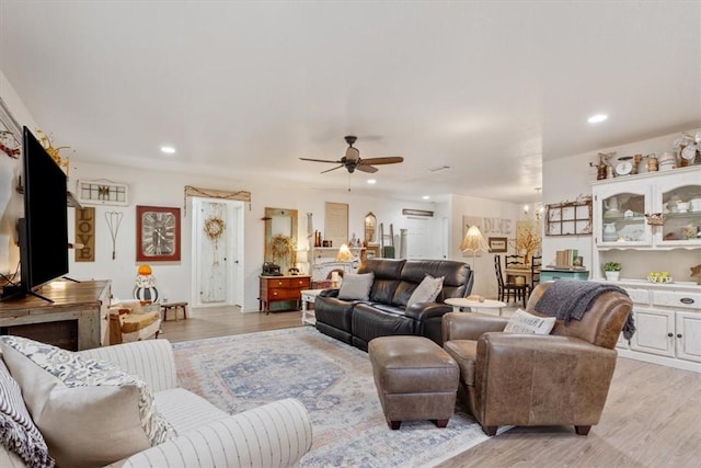 living room featuring ceiling fan and light hardwood / wood-style floors