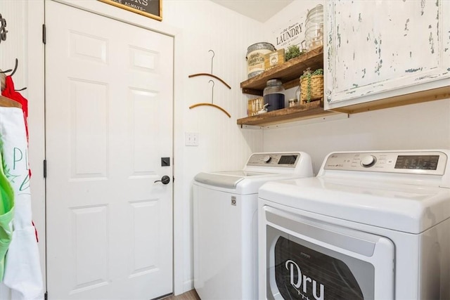 washroom featuring washing machine and dryer and cabinets