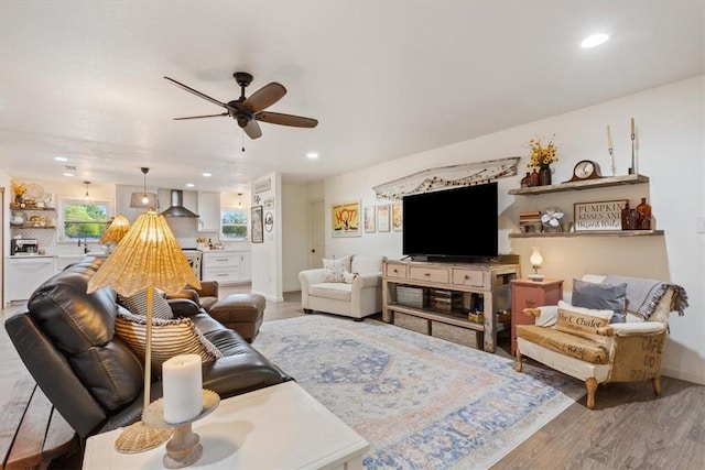 living room with ceiling fan and light hardwood / wood-style flooring