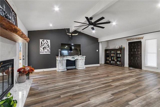 living room featuring a high end fireplace, hardwood / wood-style floors, lofted ceiling with beams, and ceiling fan