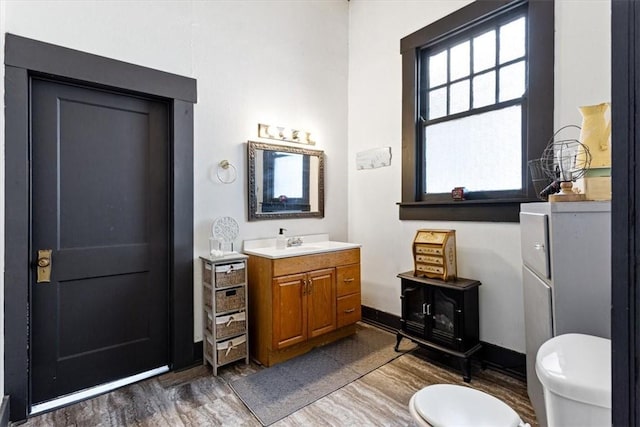 bathroom with hardwood / wood-style floors, vanity, and toilet