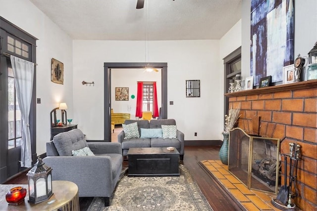 living room with a textured ceiling, ceiling fan, and dark hardwood / wood-style floors