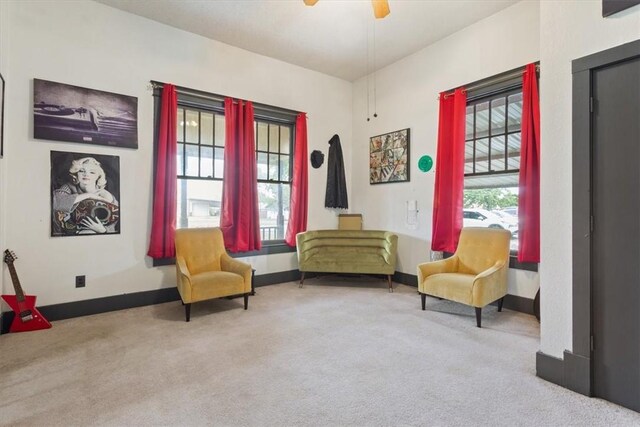 living area with ceiling fan and light colored carpet