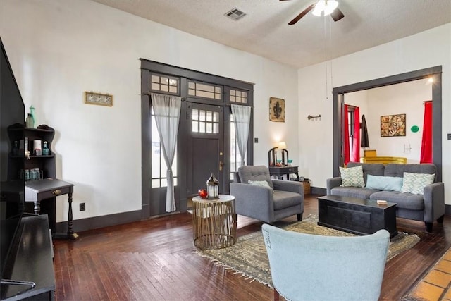 living room featuring a textured ceiling, ceiling fan, and dark wood-type flooring