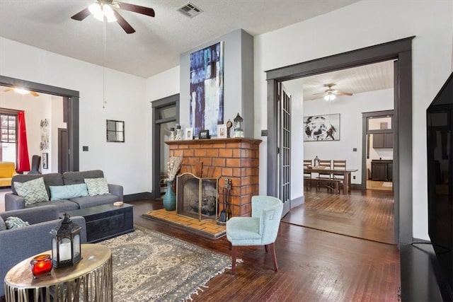 living room featuring a textured ceiling, dark hardwood / wood-style flooring, and ceiling fan