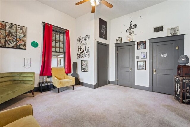 living area featuring carpet and ceiling fan