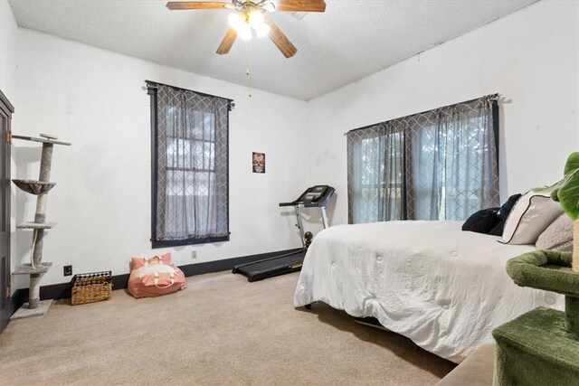 bedroom with multiple windows, ceiling fan, and carpet floors