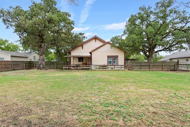 rear view of house featuring a yard