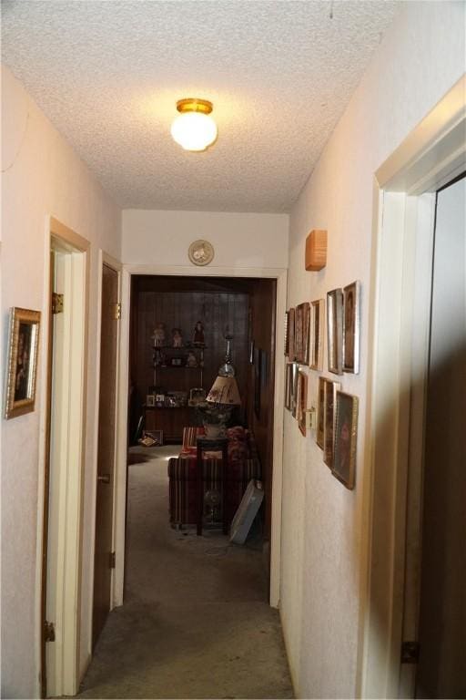 corridor with a textured ceiling and carpet