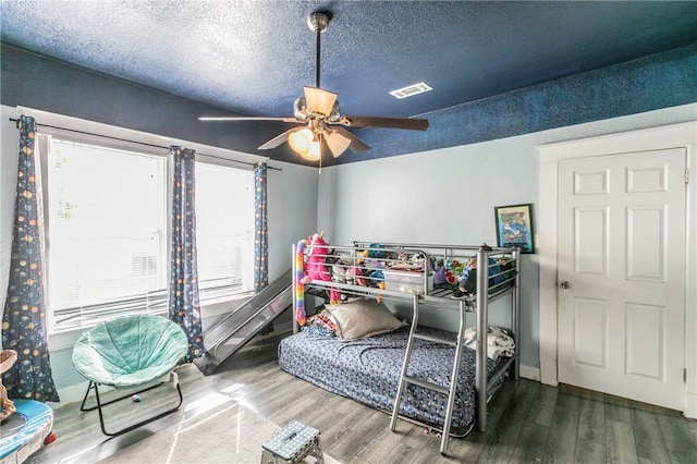 bedroom featuring a textured ceiling, hardwood / wood-style flooring, and ceiling fan