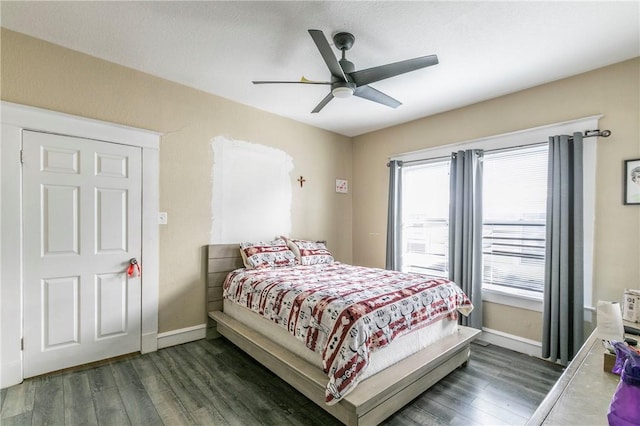 bedroom with dark hardwood / wood-style floors and ceiling fan