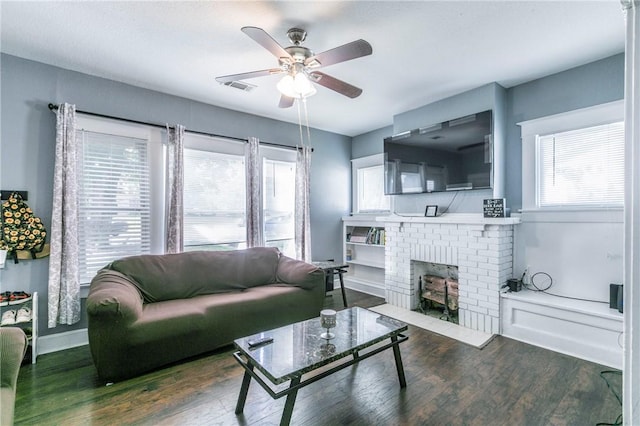 living room with ceiling fan, a fireplace, and dark wood-type flooring