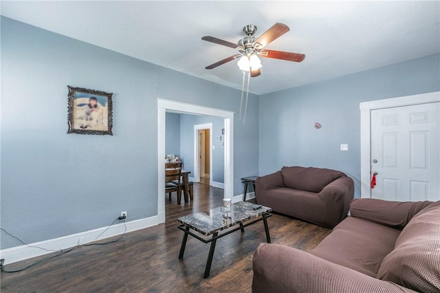 living room with ceiling fan and dark wood-type flooring