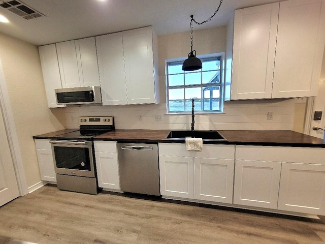 kitchen featuring stainless steel appliances, sink, and white cabinets