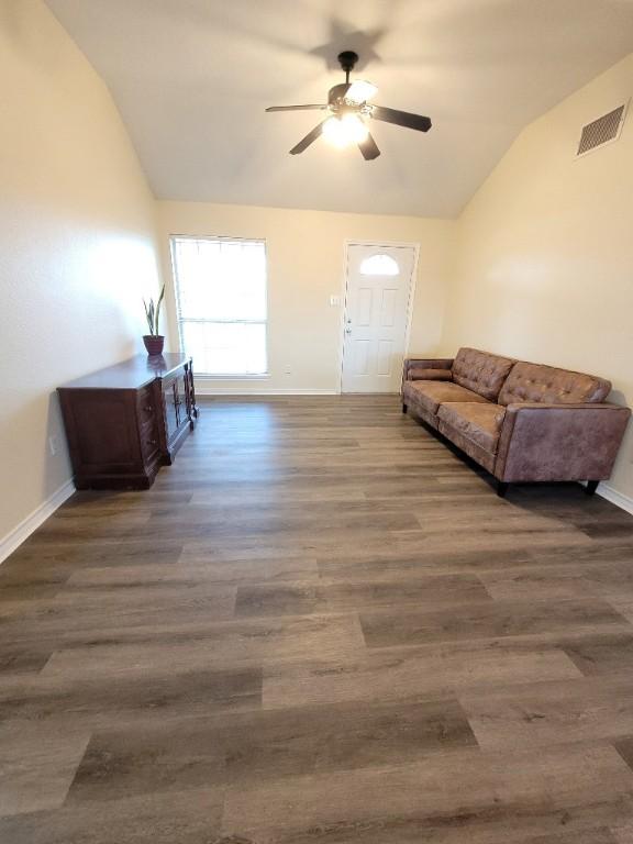 interior space with dark wood-type flooring, ceiling fan, and vaulted ceiling